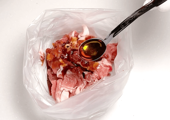 豚肉に調味料を加えて袋に入れる